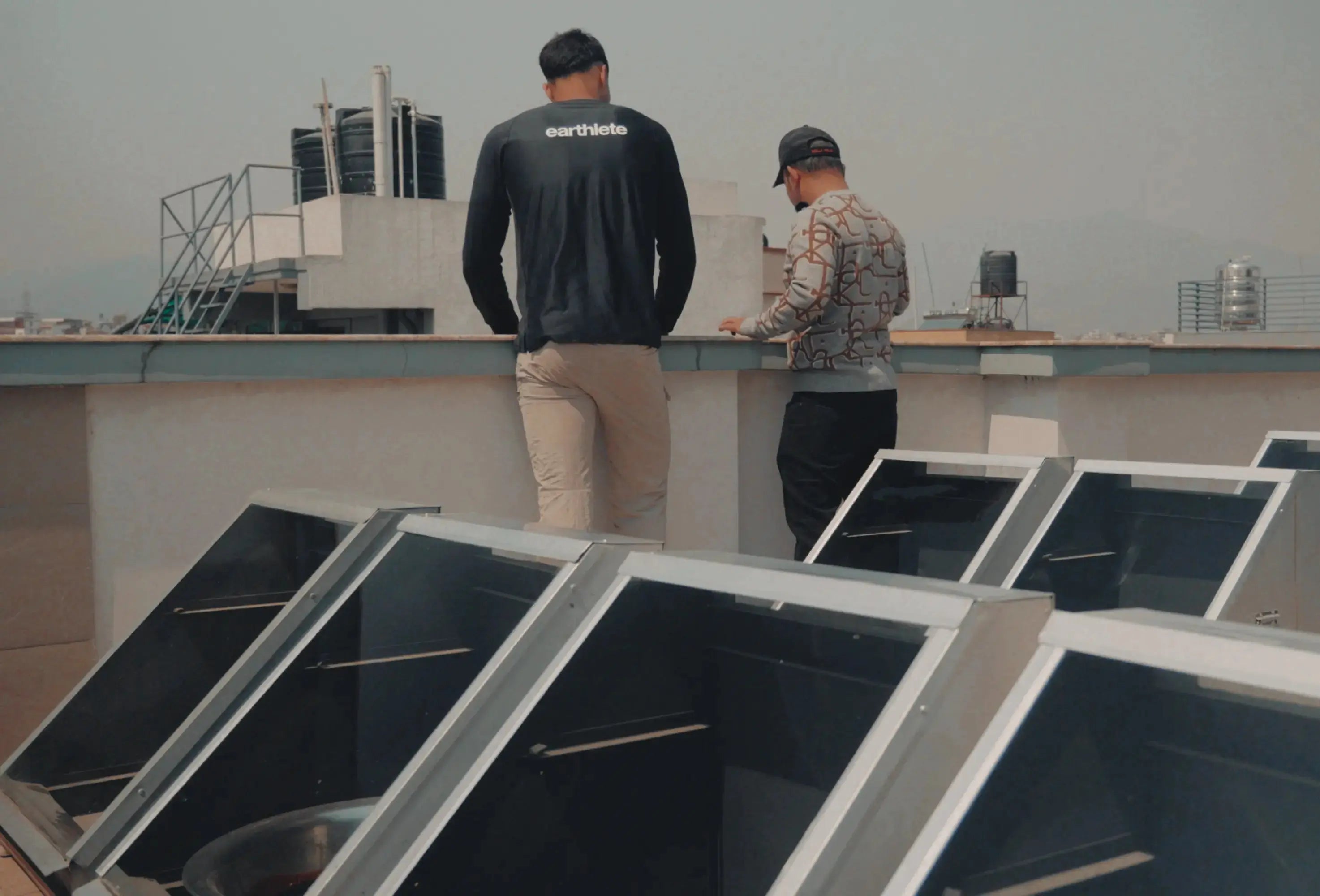 Two people on a rooftop with solar panels
