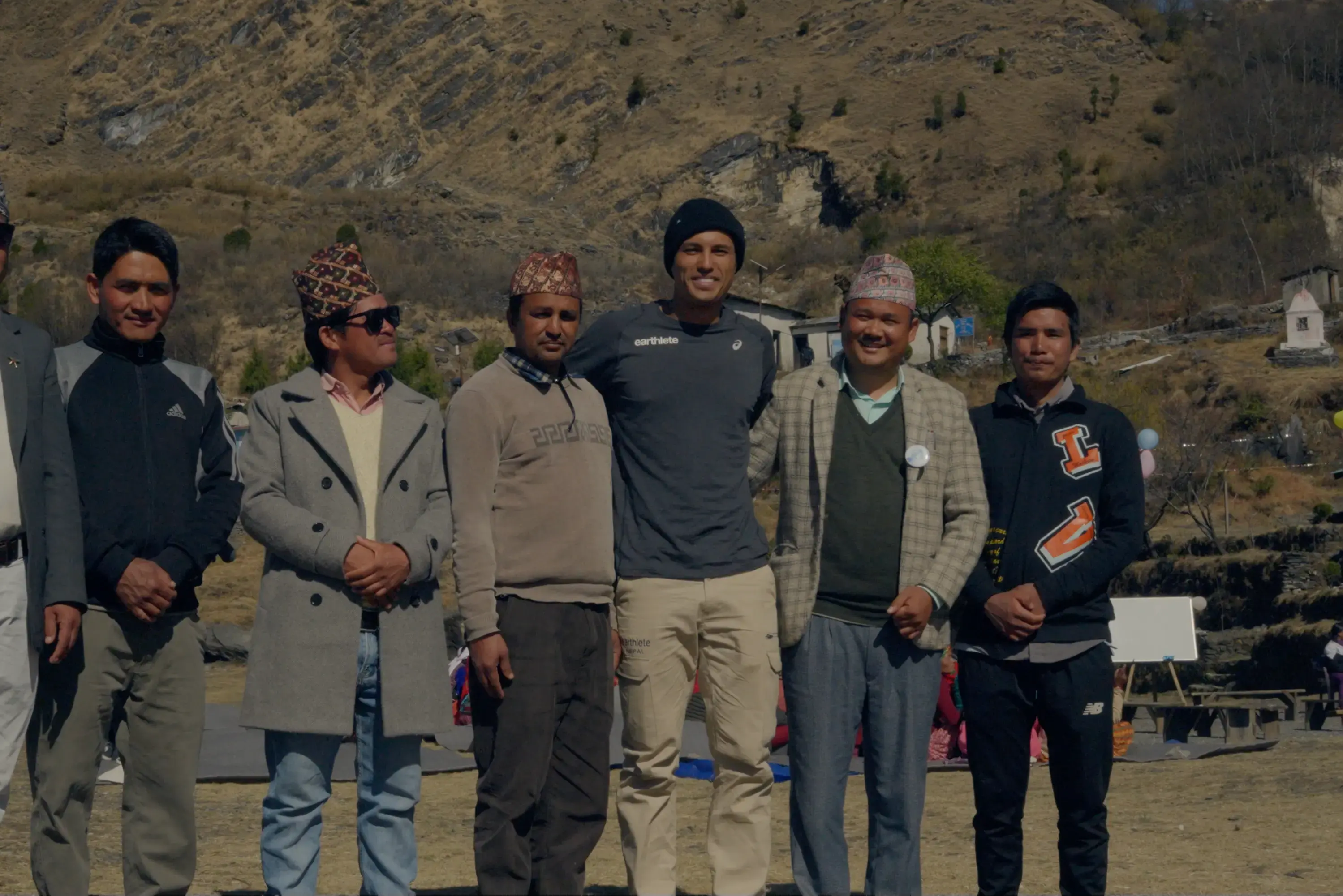 Group of people standing outdoors with a mountainous background