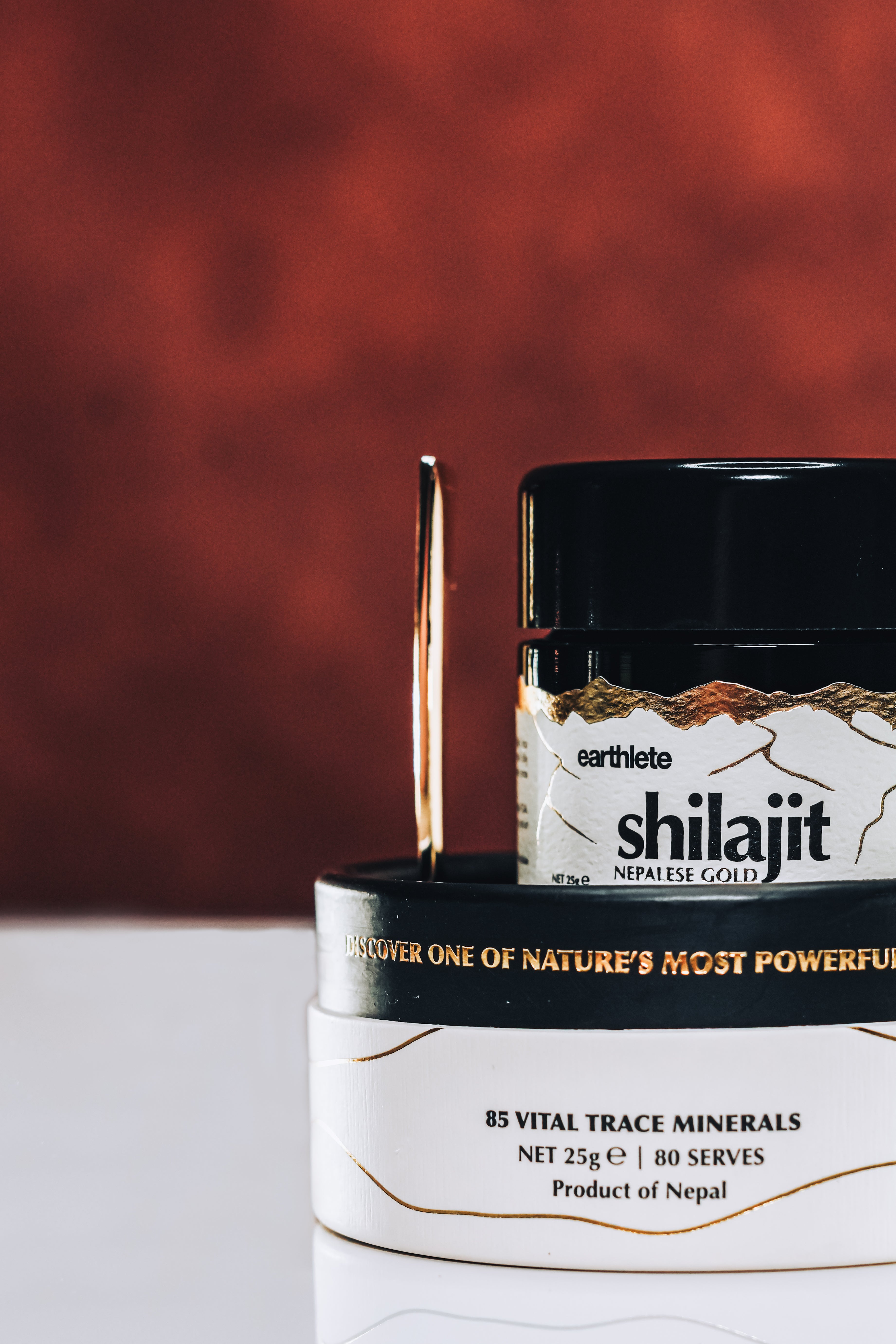 Jars of Shilajit with visible branding on a white surface against a red background